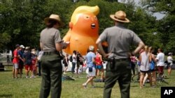 National Park Service rangers view a Baby Trump balloon before Independence Day celebrations on the National Mall in Washington, July 4, 2019. 