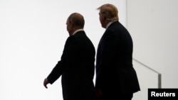 Putin dan Trump berjalan saat KTT G20 di Osaka, 28 Juni 2019. (Foto: Reuters/Kevin Lamarque)