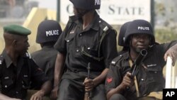 在尼日利亚政府取消燃油补贴后，警察1月5日在一注视着示威的人群