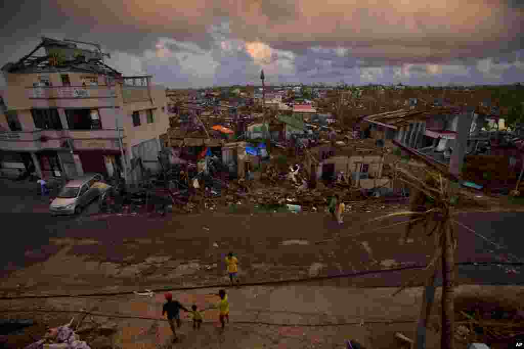 Typhoon Haiyan survivors walk along a road in the destroyed port in the town of Guiuan, Philippines, Nov. 15, 2013. 