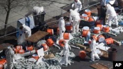 Investigators comb through the post finish line area of the Boston Marathon at Boylston Street, two days after two bombs exploded just before the finish line, April 17, 2013, in Boston.