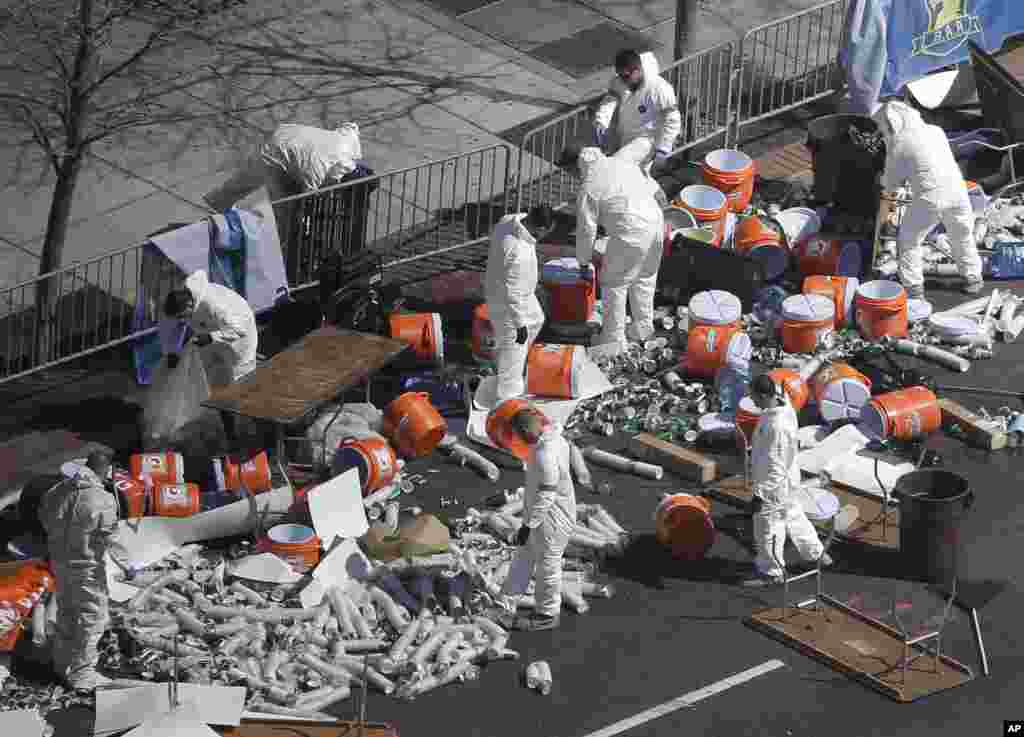 Investigators comb through the post finish line area of the Boston Marathon at Boylston Street, two days after two bombs exploded just before the finish line, April 17, 2013, in Boston.