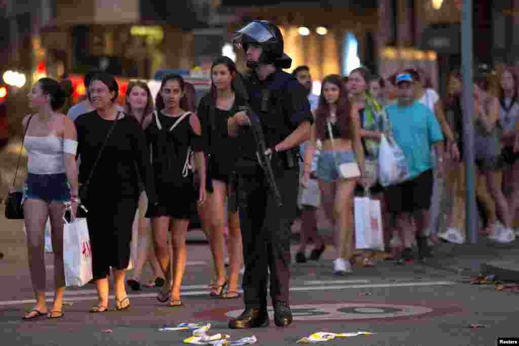 Police evacuate people after a van crashed into pedestrians near the Las Ramblas avenue in central Barcelona, Spain, Aug. 17, 2017. 