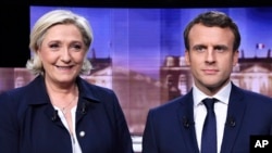 Marine Le Pen, izquierda, candidata del partido Frente Nacional, de extrema derecha y Emmanuel Macron, del movimiento En Marche ! posan antes del debate.