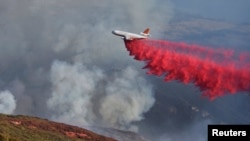 A DC-10 tanker drops retardant on the Whittier Fire in Gato Canyon near Santa Ynez Peak outside Santa Barbara, Calif., July 13, 2017. 