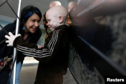 Elissa Montanti, founder of the Global Medical Relief Fund, talks with Baraka Lusambo, a Tanzanian with albinism visiting the U.S. for medical care, after his arrival at JFK International Airport in New York City, March 25, 2017.