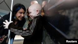Elissa Montanti, founder of the Global Medical Relief Fund, talks with Baraka Lusambo, a Tanzanian with Albinism visiting the U.S. for medical care, after his arrival at JFK International Airport in New York City, March 25, 2017. 