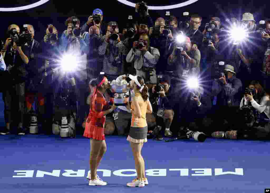 Martina Hingis, right, of Switzerland and Sania Mirza, left, of India hold their trophy aloft after defeating Czech Republic&rsquo;s Andrea Hlavackova and Lucie Hradecka in the women&#39;s doubles final at the Australian Open tennis championships in Melbourne.