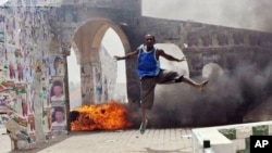 A man jumps during a demonstration in Nigeria's northern city of Kano where running battles broke out between protesters and soldiers on April 18, 2011