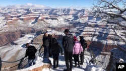 Turistas aprovechan para tomarse fotografías en el Gran Cañón cubierto de nieve, algo poco inusual. 