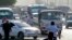 A worker directs vehicles queuing in line at a petrol station, Cairo, March 12, 2013.