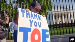 Hugh Kieve, 10, of Washington, holds a sign outside the White House in Washington, SJuly 21, 2024, as he and his family come out to show support for President Joe Biden.