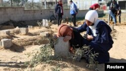 FILE - A Palestinian woman reacts at the grave of her son killed in an Israeli strike, amid the ongoing conflict between Israel and the Palistinian Islamist group Hamas, in Khan Younis in the southern Gaza Strip, January 18, 2024.
