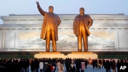 Citizens visit the bronze statues of their late leaders Kim Il Sung, left, and Kim Jong Il on Mansu Hill in Pyongyang, North Korea Thursday, Dec. 16, 2021, on the occasion of 10th anniversary of demise of Kim Jong Il. 