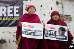 FILE - Two Tibetan nuns in Dharmsala, India, hold placards demanding that China release Tashi Wangchuk, an outspoken campaigner for the rights of Tibetans, Jan. 27, 2017.