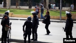 Riot police take their positions near the site of a series of explosions in front of Cairo University April 2, 2014
