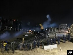 In this image provided by Morton County Sheriff’s Department, law enforcement and protesters clash near the site of the Dakota Access pipeline, Nov. 20, 2016.