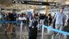 Passengers arrive at Ronald Reagan Washington National Airport on July 19, 2024, in Arlington, Virginia, during a major worldwide computer systems outage.