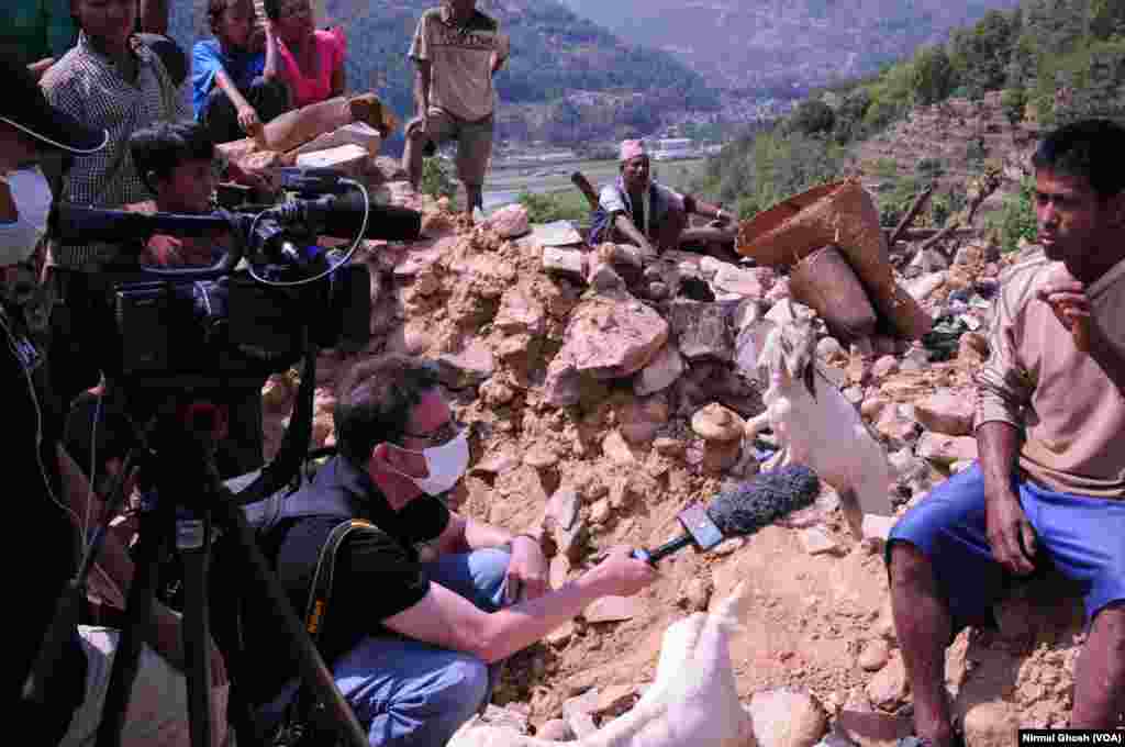VOA Correspondent Steve Herman, w/ videographer Zinlat Aung, interview a man sitting atop the rubble of his home in Majigaon village, Sindhupolchok district, Nepal which crumbled in the April 2015 earthquake. 