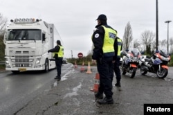 French police officers provide security as they control the crossing of vehicles on the Belgium border between the two countries, following the deadly Paris attacks, in Crespin, France, Nov. 14, 2015.
