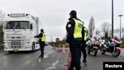 French police officers provide security as they control the crossing of vehicles on the Belgium border between the two countries, following the deadly Paris attacks, in Crespin, France, Nov. 14, 2015.