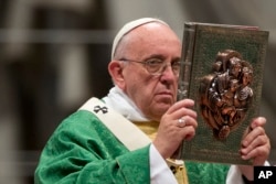 Pope Francis calls marriage an 'indissoluble bond' between men and women. He's shown raising the book of Gospels during the opening Mass of the Synod of bishops, in St. Peter's Basilica at the Vatican, Oct. 4, 2015.