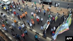 FILE - Students and workers carry placards as they march on the Lagos-Ikorodu highway to protest against the suspension of academic activities following a nation-wide strike embarked by lecturers in state-owned universities in Lagos.