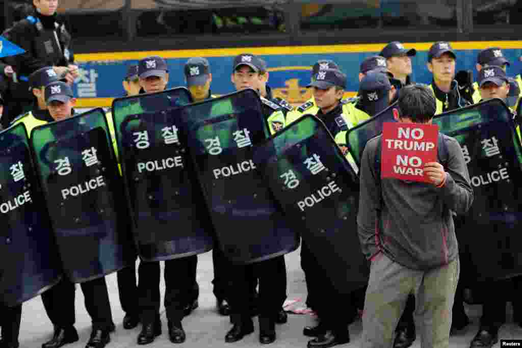 首尔的防暴警察和一名反对川普和战争的示威者（2017年11月7日）