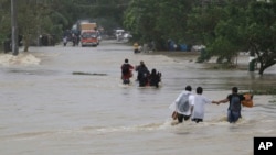 Residents brave a raging floodwater brought about by Typhoon Nari at San Ildefonso township, Bulacan province, north of Manila, Philippines, Oct. 12, 2013.