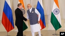 Indian Prime Minister Narendra Modi, right, shakes hand with Russian President Vladimir Putin prior to their bilateral meeting, in Goa, India, Oct. 15, 2016. The two leaders signed several agreements as part of apparent efforts aimed at rejuvenating ties.