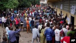 Hundreds of Congolese voters who have been waiting at the St. Raphael school in the Limete district of Kinshasa Sunday Dec. 30, 2018, storm the polling stations after the voters listings were finally posted five hours after the official start of voting. 
