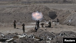 Members of the Iraqi army and Shi'ite fighters launch a mortar toward Islamic State militants on the outskirts of the city of Falluja, Iraq May 19, 2015.
