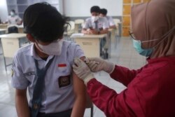 Seorang petugas medis memberikan suntikan vaksin Sinovac COVID-19 kepada seorang siswa saat berlangsungnya kampanye vaksinasi untuk anak-anak usia 12-17 tahun di Medan, Sumatera Utara, Indonesia, Kamis, 12 Agustus 2021. (AP Photo/Binsar Bakkara)