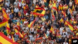 People wave Spanish national flags as thousands packed the central Cibeles square to in Madrid, Spain, Saturday, Sept. 30, 2017.