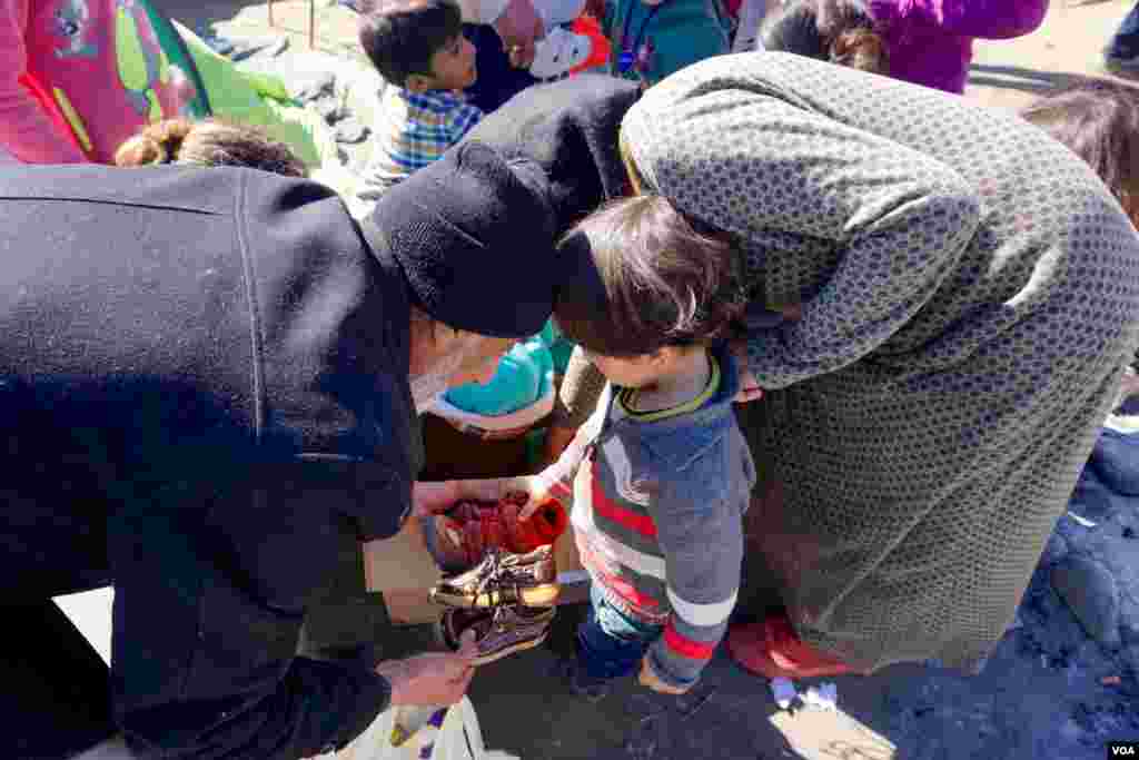 Man and woman with child at Idomeni refugee camp on the Greece-Macedonia border, March 8, 2016. (Jamie Dettmer for VOA)