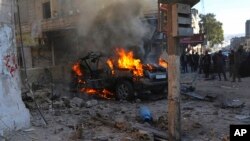 This photo provided by the Syrian Civil Defense White Helmets, which has been authenticated based on its contents and other AP reporting, shows Syrians around a burning car hit by a shell, in the town of Afrin, north of Aleppo.&nbsp;The rocket attack on Afrin, controlled by Turkey-backed opposition fighters, killed several civilians and wounded over a dozen people, Syrian rescuers and a war monitor said.