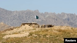 FILE - A Pakistani flag flies on top of a Pakistani check point at the Goshta district of Nangarhar province, where Afghanistan shares a border with Pakistan, May 2, 2013. 