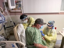 COVID-19 patient Brian Parisi from Orange County is treated by staff in the ICU at Providence St Joseph Hospital in Orange, California, July 23, 2021.