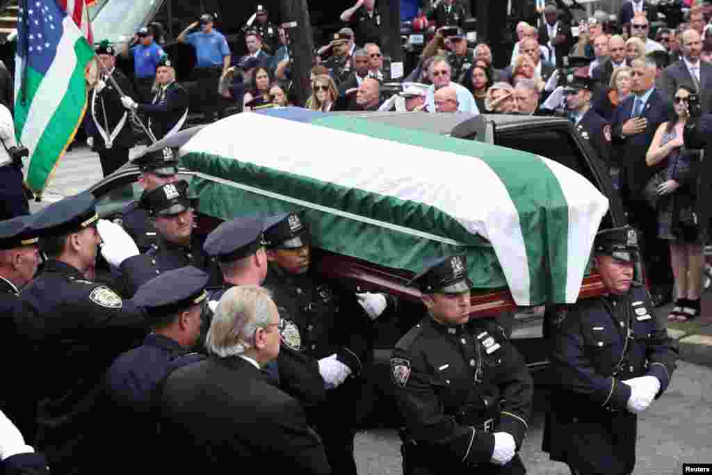 The casket of Luis Alvarez, a former New York City police detective who was diagnosed with cancer after working at Ground Zero, is carried into a church for his funeral in New York.