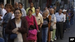 People line up outside a polling station during congressional elections in Caracas, Venezuela, Sunday, Sept. 26, 2010.