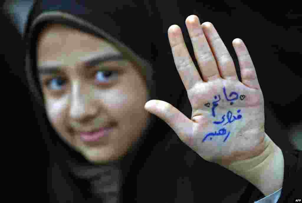 An Iranian girl shows her hand with a slogan reading in Farsi: &quot;Ready to sacrifice my self for the leader&quot; at the tomb of Iran&#39;s late founder of the Islamic Republic, Ayatollah Ruhollah Khomeini, on the occasion of 40th anniversary of Khomeini&#39;s return from exile from Paris at his mausoleum in southern Tehran, Feb. 1, 2019.