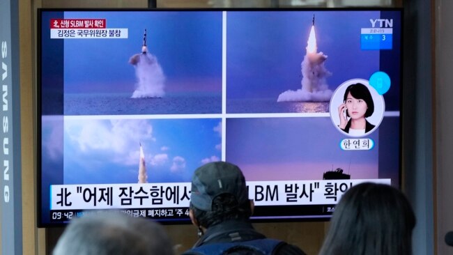 FILE - People watch a TV screen showing images of North Korea's ballistic missile launch from a submarine, during a news program at Seoul Railway Station in Seoul, South Korea, Oct. 20, 2021.