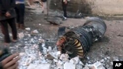 A photo provided by the Ibaa News Agency, the media arm of al-Qaida’s branch in Syria, reportedly shows part of a Russian jet that was shot down by rebel fighters over Idlib province in Syria, Feb. 3, 2018.