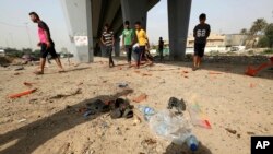 Civilians gather at the site of a suicide bomb attack in Baghdad's western Iskan neighborhood, Iraq, Oct. 29, 2016. Iraqi officials say a suicide bomber targeting Shiiite pilgrims has killed seven people and wounded more than 20 in the Iraqi capital, Bagh