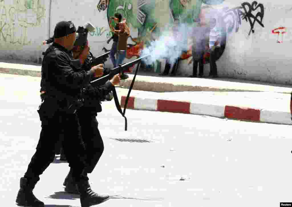 Police officers fire tear gas to break up a protest in the city of Kairouan, Tunisia. Supporters of the hardline Islamist group Ansar al-Sharia clashed with police after the government banned its annual rally, saying it posed a threat to society.