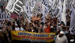 FILE - In this Feb. 26, 2011 file photo, supporters of Hafiz Saeed, the leader of a banned Islamic group Jamaat-ud-Dawa, an alias of the proscribed Lashkar -e-Taiba terror group, rally against India and United States in Lahore, Pakistan.