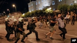 Greek riot police officers charge protesters at Syntagma square in front of the Greek Parliament in central Athens, during minor scuffles following a peaceful ongoing rally against plans for new austerity measures, June 22, 2011
