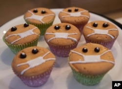 Timed to the current outbreak of the worldwide coronavirus, Covid-Free Cupcakes with icing masks are on display in the Cheesecake House and Restaurant in Bangkok, Thailand, Monday, March 23, 2020.