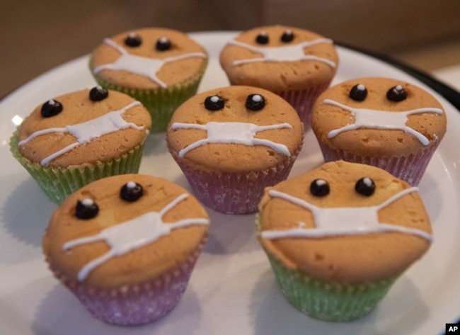 Timed to the current outbreak of the worldwide coronavirus, Covid-Free Cupcakes with icing masks are on display in the Cheesecake House and Restaurant in Bangkok, Thailand, Monday, March 23, 2020.