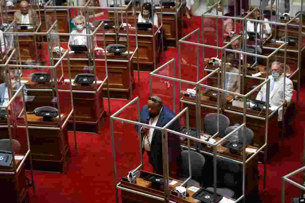 Rhode Island Democratic state Rep. Raymond Hull, below center, holds a microphone on the floor of the House Chamber separated by plastic protective barriers at the start of a legislative session, at the Statehouse in Providence, June 17, 2020.